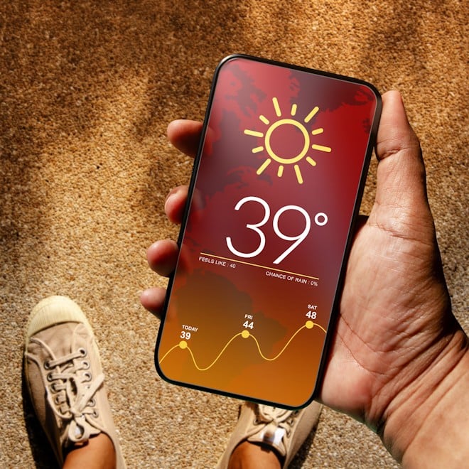 Hand holding phone with temperature showing on screen